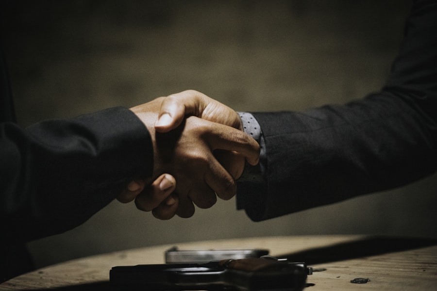 Two people shaking hands across a table