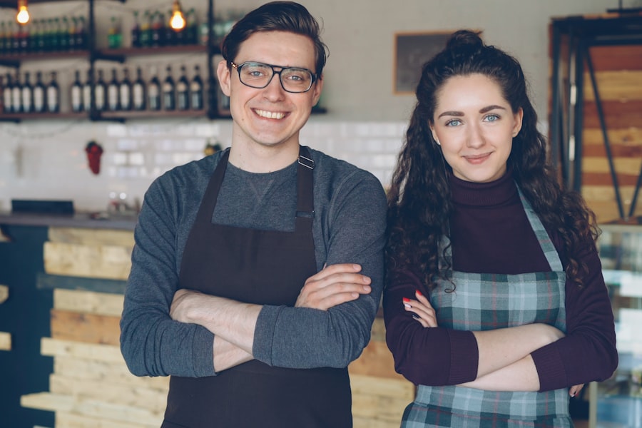 Two small business owners standing proudly in their cafe