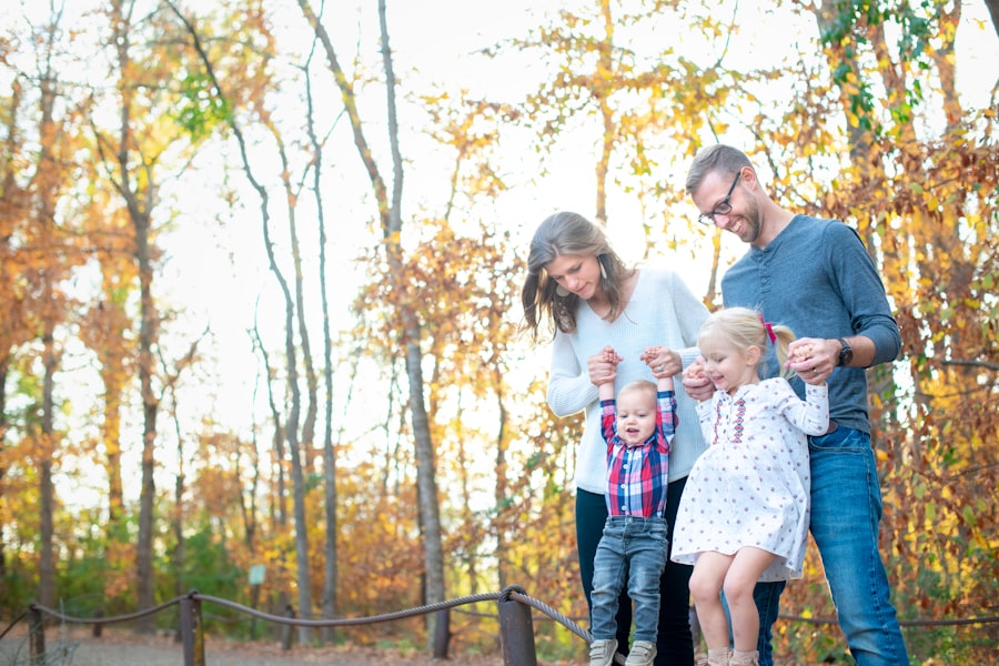 Parents walking outdoors holding hands with their two young children