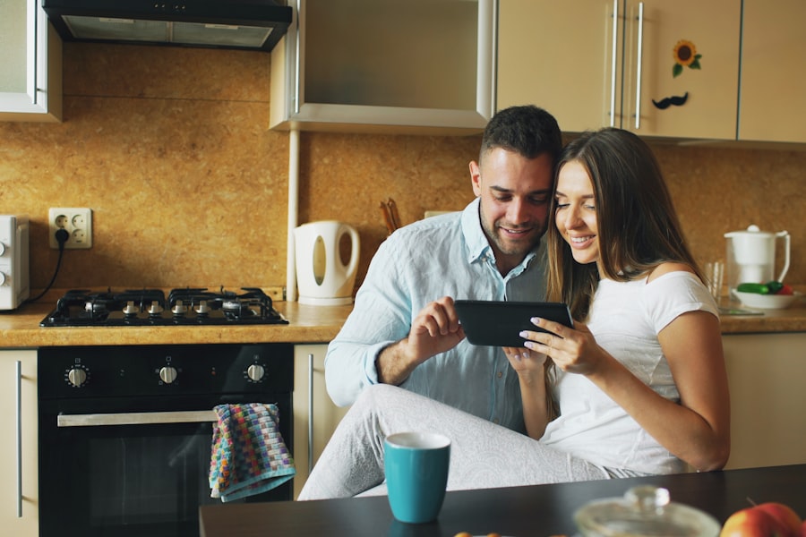 A couple reviewing finances together on a tablet in their kitchen